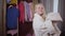 Portrait of little Caucasian blond girl drying hair with towel. Positive smiling child resting at home after shower