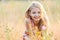 Portrait of little cheerful girl in a meadow