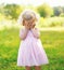 Portrait of little child closes her face outdoors