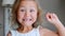 Portrait of little child girl is showing her lost milk tooth and smiling