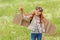 portrait of little child in pilot costume with wooden toy plane standing