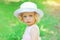 Portrait of little curly girl child wearing a white hat