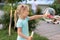 Portrait of little cute caucasian blond girl having fun and joy blowing big soap bubbles playing on city street park outdoors.