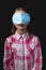 Portrait of a little cute girl with a medical mask isolated on black background