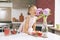 Portrait of a little cute girl sniffing a bunch of hydrangeas. The girl sniffs flowers, next to the table are muffins, a glass