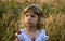 Portrait of a little girl 3-4 years old in a national Ukrainian embroidery on the background of a harvested wheat field, sunset.