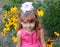 Portrait of the little girl against the background of the blossoming coneflowers