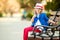 Portrait of little girl on bench in a park showing thumb up