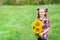 Portrait of little girl with big great gorgeous sunflower bouquet in her hands on the field background