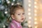 Portrait of little girl on the blurred illuminated background