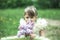 Portrait of little girl with a bouquet of lilacs in the garden.