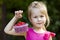 Portrait of a little girl child holdind small basket of ripe raspberries. Close-up