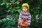 Portrait of a little girl with a crop of apples .