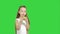 Portrait of a little girl eating green apple on a green screen, chroma key