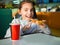 Portrait of a little girl eating pizza at a cafe at dinner. Fast food.