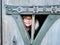 Portrait of a little girl with eye glasses in wooden house of playground for children.