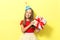 Portrait of a little girl in a festive cap and with a gift in her hands