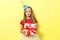 Portrait of a little girl in a festive cap and with a gift in her hands