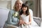 Portrait of little girl greeting mature grandmother presenting flowers