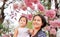 Portrait little girl and her mom with Beautiful Tabebuia rosea blooming in spring season at garden outdoor