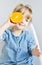 Portrait of Little Girl Holding Halves of Orange Near Eyes