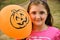 Portrait of a little girl holding orange Halloween balloon