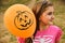 Portrait of a little girl holding orange Halloween balloon