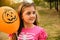 Portrait of a little girl holding orange Halloween balloon