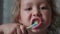 Portrait of little girl is intensively brushing her teeth in bathroom