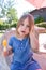 Portrait of little girl with orange ice lolly in park