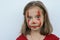 Portrait of a little girl smeared with red paint face
