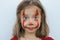 Portrait of a little girl smeared with red paint face