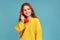 Portrait of little girl talking landline telephone holding handset, looking away with toothy smile.