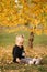 Portrait of little girl walking in the part in autumn. Blond hairl female kid outside. Warm autumn