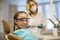 Portrait of a little girl wearing goggles sitting in a chair in the dental office