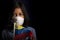 Portrait of little girl wearing medical mask and holding hopefully the flag of Venezuela