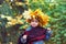 Portrait of a little girl in a wreath of autumn leaves