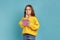 Portrait of little girl writing in notebook, thinking, taking notes, school child doing homework.