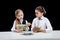 Portrait of little girls sitting at table and calculating money