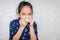 Portrait of Little kid girl wipe the mucus and looking at camera with blurred background