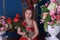 Portrait of a little princess girl in a red dress with flowers i
