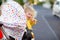 Portrait of little sad toddler girl sitting in stroller and going for a walk. Crying baby child does not want sitting in