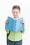 Portrait of little schoolboy with book on white background.
