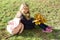 Portrait of little schoolgirl with yellow maple leaves school bag, on sunny autumn day