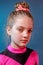 Portrait of little serious girl cheerleader in color backlight