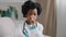 Portrait little serious kid girl in medical gown pretending be doctor playing in hospital looking at camera posing