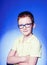 Portrait of a little smiling boy in a funny glasses and tie. Back to school. Smart boy using microscope over blue