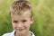 Portrait of a little smiling boy with golden blonde straw hair i