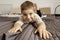 Portrait of little, smiling caucasian boy on the bed at home. Cute child relaxing, resting in bedroom. Positive emotions