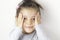 Portrait of little smiling impressed cheerful girl in checkered holding her hands near face.